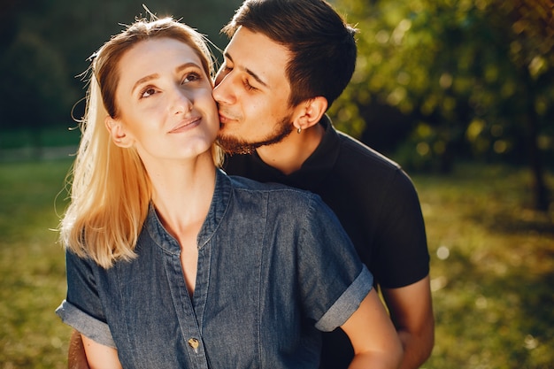 Elegante pareja amorosa de pie en un parque.