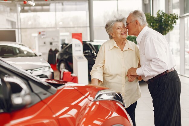 Elegante pareja de ancianos en un salón del automóvil