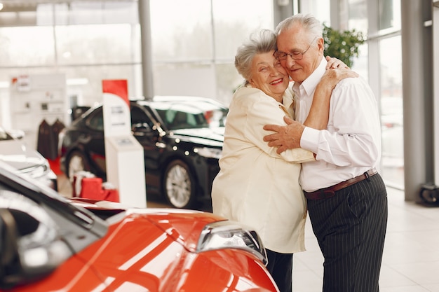 Elegante pareja de ancianos en un salón del automóvil