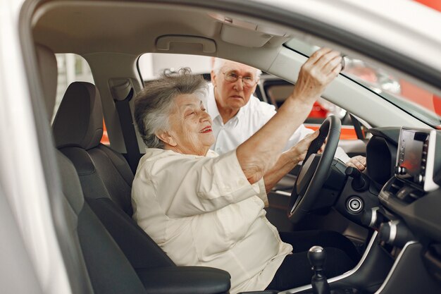 Elegante pareja de ancianos en un salón del automóvil