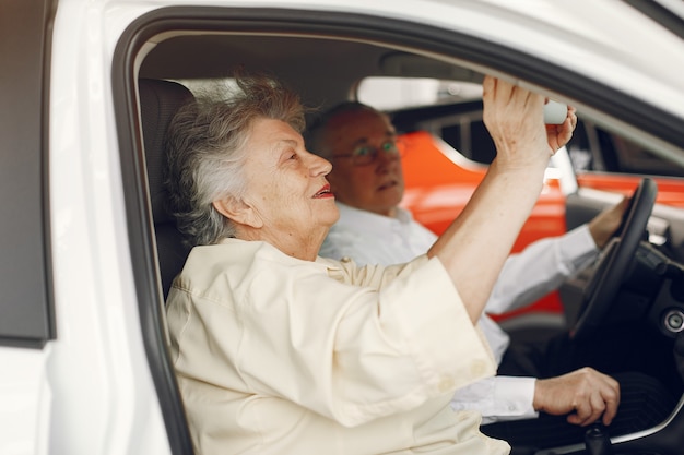 Elegante pareja de ancianos en un salón del automóvil