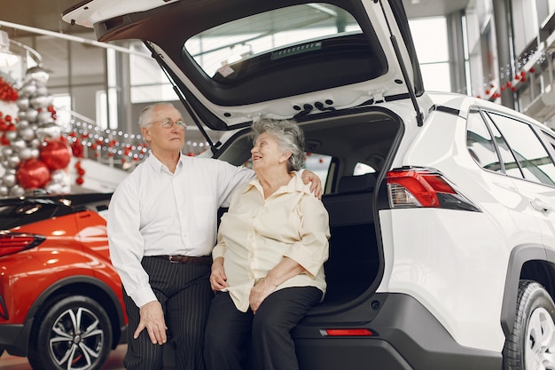 Elegante pareja de ancianos en un salón del automóvil