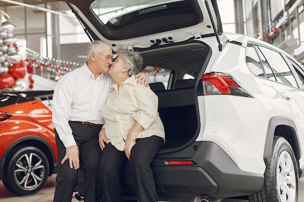 Elegante pareja de ancianos en un salón del automóvil