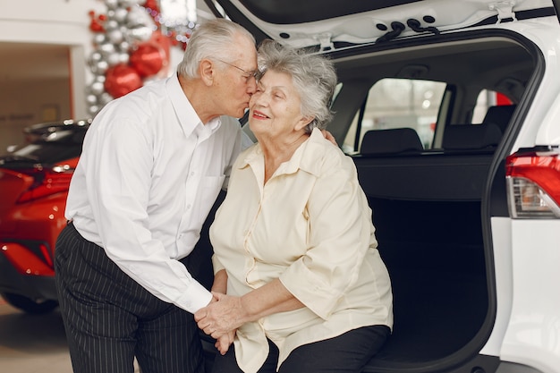 Elegante pareja de ancianos en un salón del automóvil