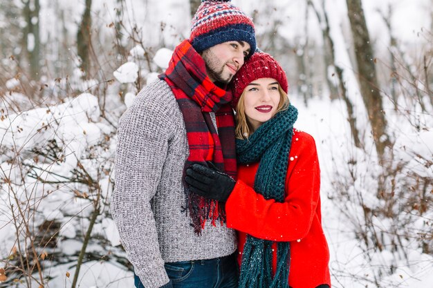 Elegante pareja brillante abrazando en el bosque