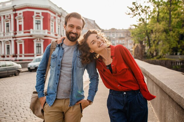 Elegante pareja de enamorados caminando abrazando en la calle en viaje romántico