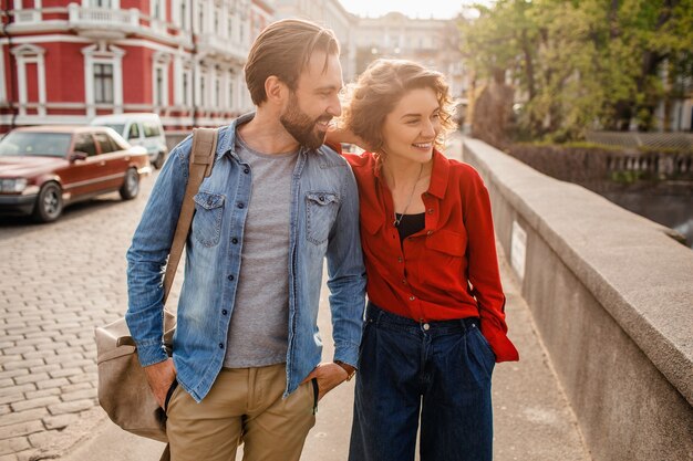 Elegante pareja de enamorados caminando abrazando en la calle en viaje romántico