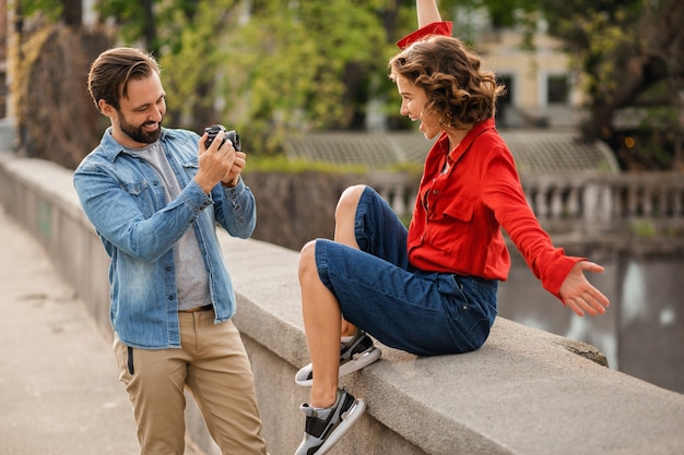 Elegante pareja de enamorados sentados en la calle en viaje romántico, tomando fotos