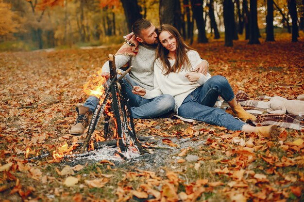 Elegante pareja pasa tiempo en un parque de otoño