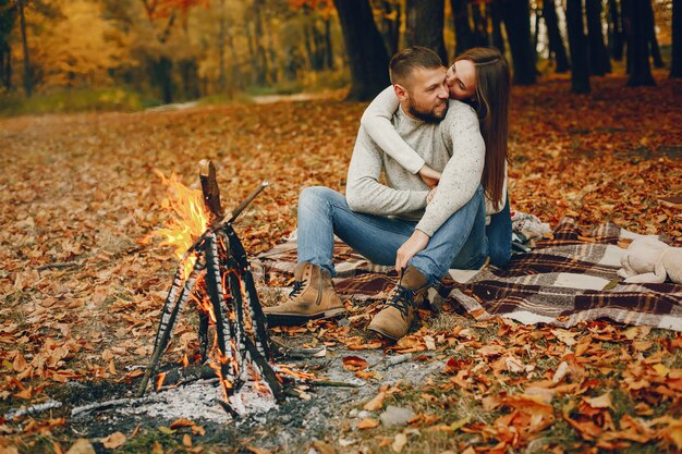 Elegante pareja pasa tiempo en un parque de otoño
