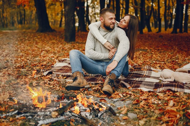 Elegante pareja pasa tiempo en un parque de otoño