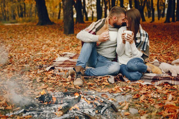 Elegante pareja pasa tiempo en un parque de otoño
