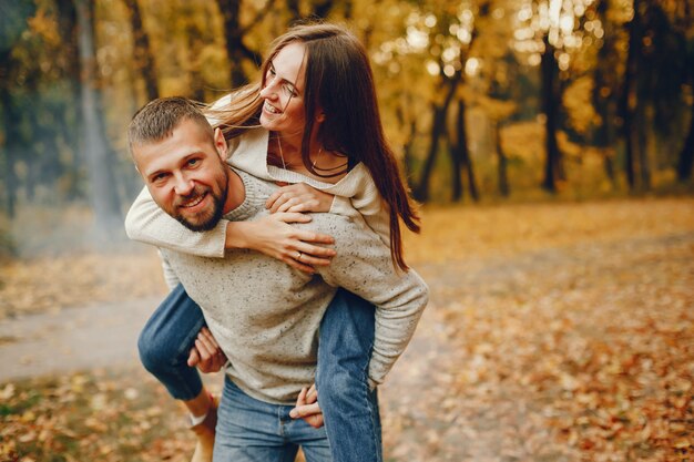 Elegante pareja pasa tiempo en un parque de otoño