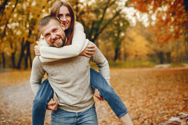 Elegante pareja pasa tiempo en un parque de otoño