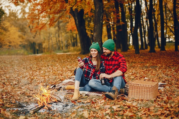 Elegante pareja pasa tiempo en un parque de otoño