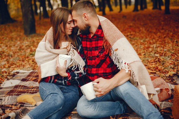 Elegante pareja pasa tiempo en un parque de otoño