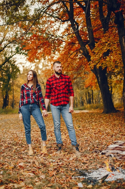 Elegante pareja pasa tiempo en un parque de otoño