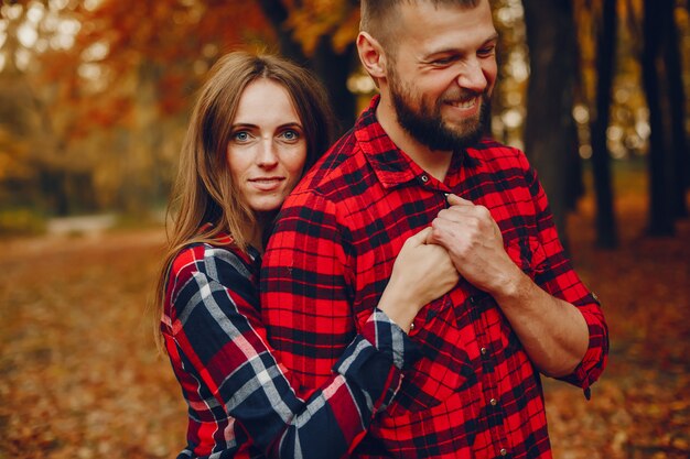 Elegante pareja pasa tiempo en un parque de otoño