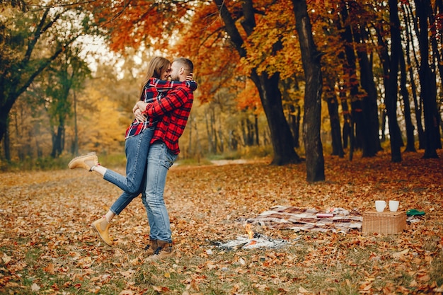 Elegante pareja pasa tiempo en un parque de otoño