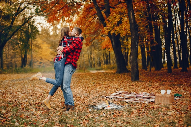 Elegante pareja pasa tiempo en un parque de otoño