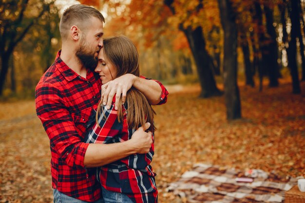 Elegante pareja pasa tiempo en un parque de otoño