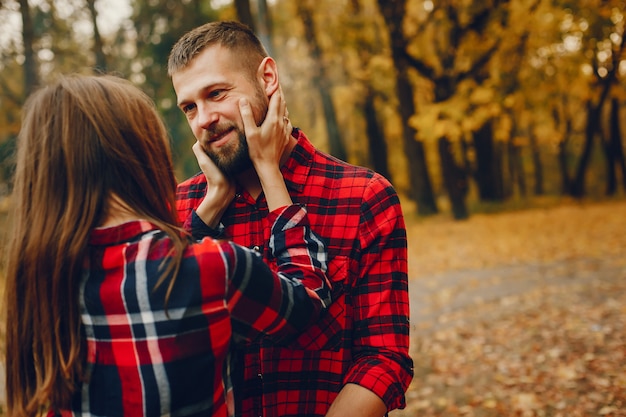 Elegante pareja pasa tiempo en un parque de otoño