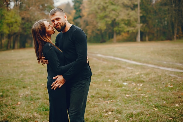 Elegante pareja pasa tiempo en un parque de otoño