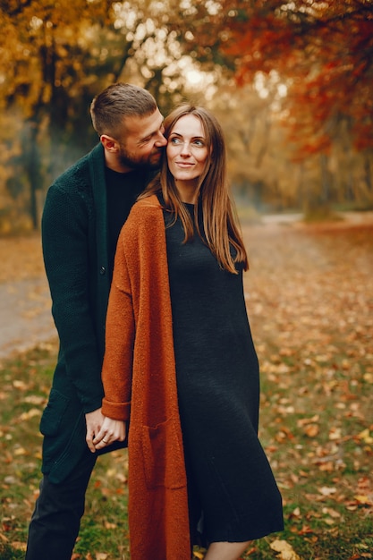 Elegante pareja pasa tiempo en un parque de otoño