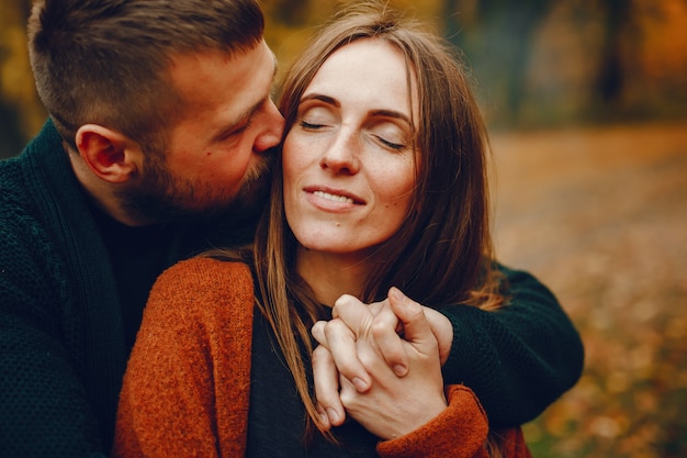 Elegante pareja pasa tiempo en un parque de otoño