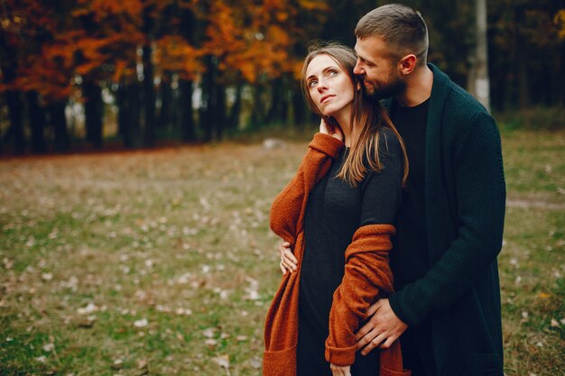 Elegante pareja pasa tiempo en un parque de otoño