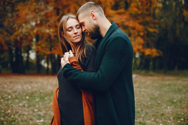 Elegante pareja pasa tiempo en un parque de otoño