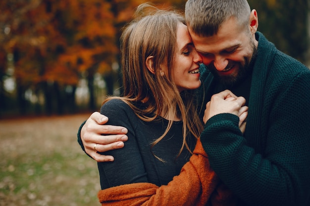 Elegante pareja pasa tiempo en un parque de otoño