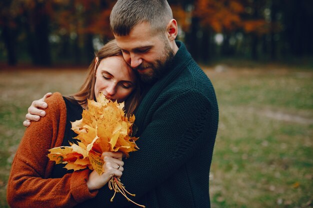 Elegante pareja pasa tiempo en un parque de otoño