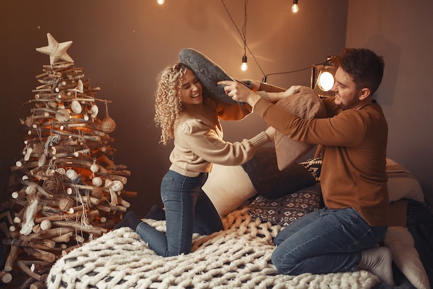 Foto gratuita elegante pareja sentada en casa cerca del árbol de navidad