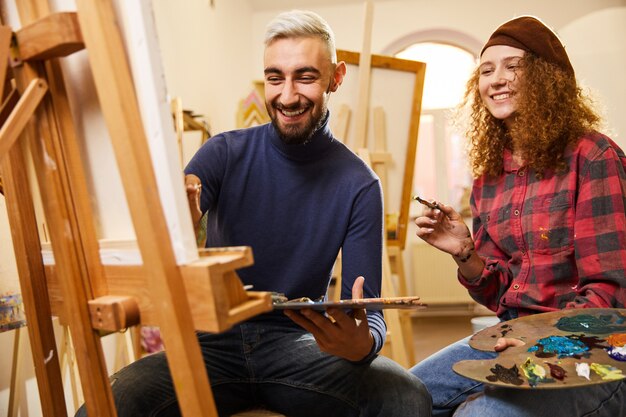 Elegante pareja sonriente dibujar una pintura