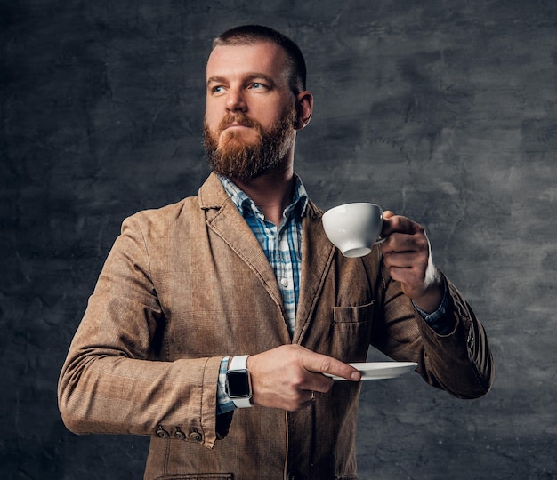 Elegante pelirrojo barbudo hombre hipster bebe café.