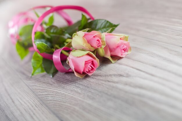 Elegante ramo de rosas rosadas en madera