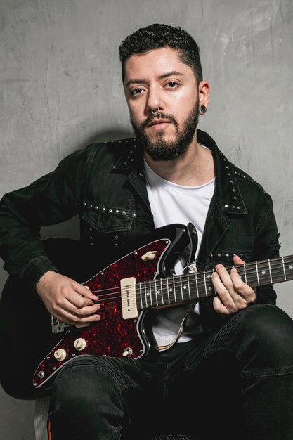 Elegante rockero tocando la guitarra eléctrica