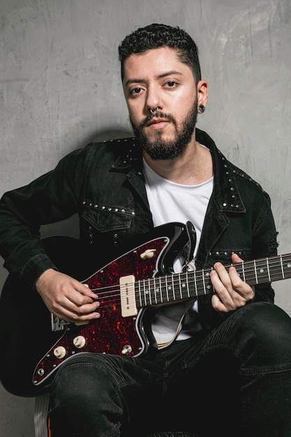 Elegante rockero tocando la guitarra eléctrica