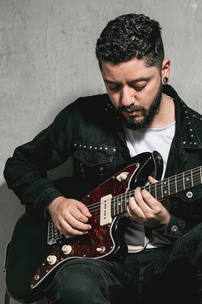 Elegante rockero tocando la guitarra vintage