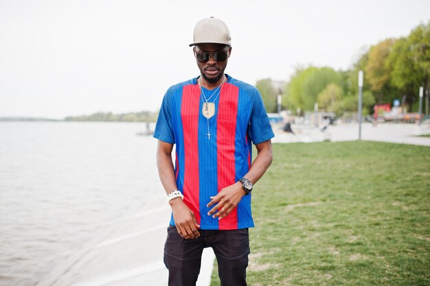 Elegante ropa de niño afroamericano en camiseta de fútbol y gafas de sol Retrato de hombre deportivo negro