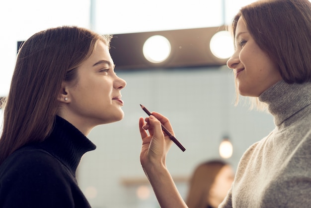 Elegante usando lápiz labial en modelo