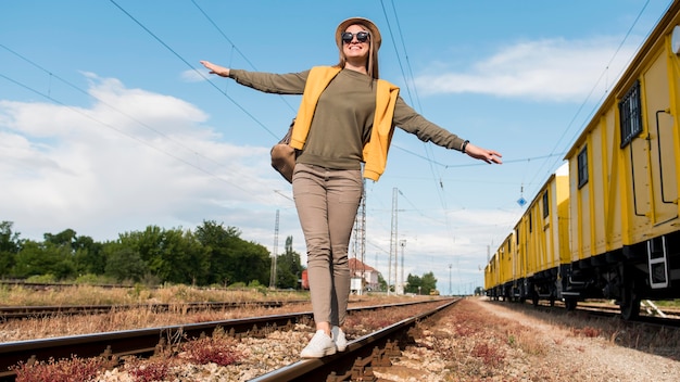 Elegante viajero con sombrero caminando en ferrocarril