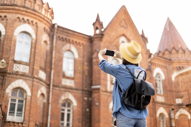 Elegante viajero con sombrero tomando fotos de vacaciones