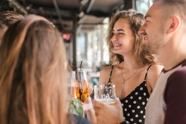 Elegantes amigos disfrutando de bebidas con amigos