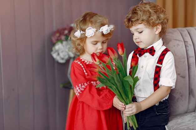 Elegantes niños pequeños con ramo de tulipanes