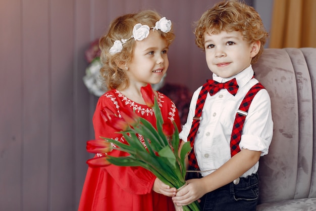 Elegantes niños pequeños con ramo de tulipanes