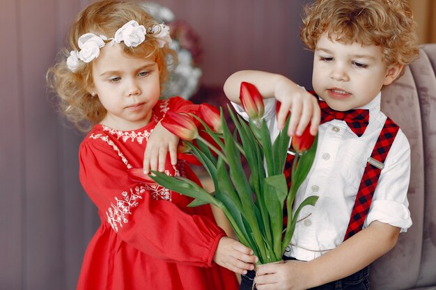 Elegantes niños pequeños con ramo de tulipanes