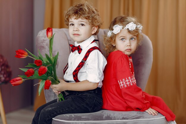 Elegantes niños pequeños con ramo de tulipanes