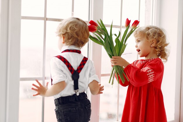 Elegantes niños pequeños con ramo de tulipanes